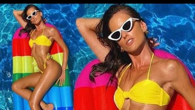 'Izabel Goulart flaunts her impossibly toned physique perched on a Popsicle pool float sporting a tee'